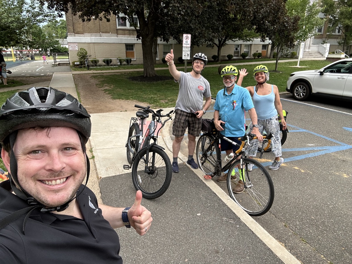 Verona Bike Loop riders gathering with their bicycles near a school
