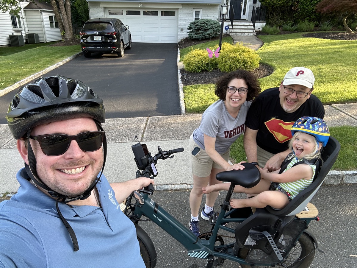 A family greeting community riders during a neighborhood ride
